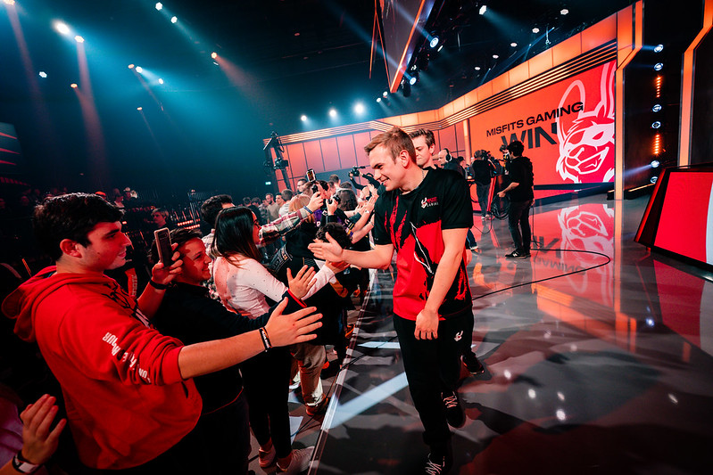 Esports player greets fans after a match while walking off stage